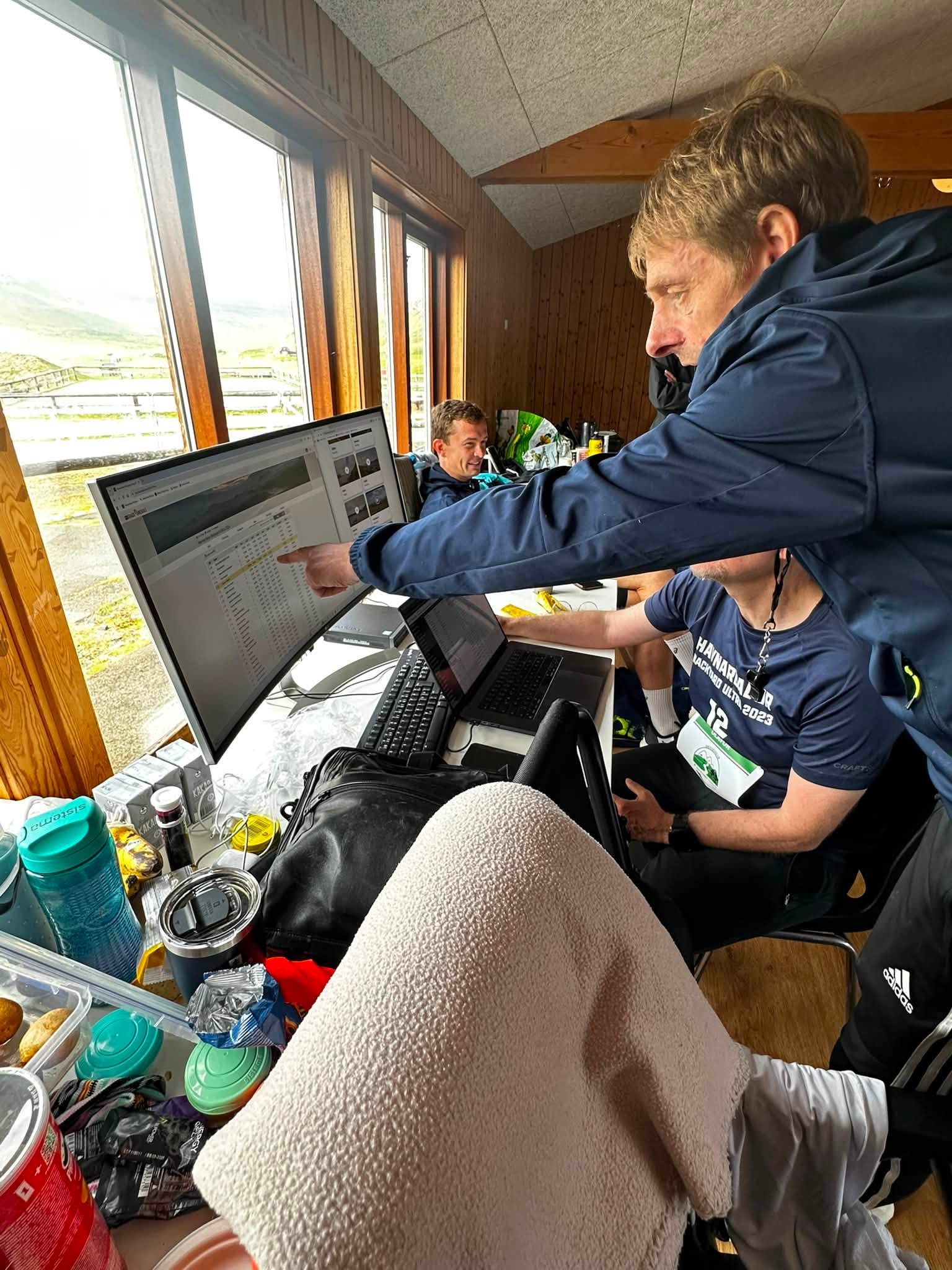 Havnardalur Backyard Ultra organisers reviewing live race information together inside the event venue in 2026.